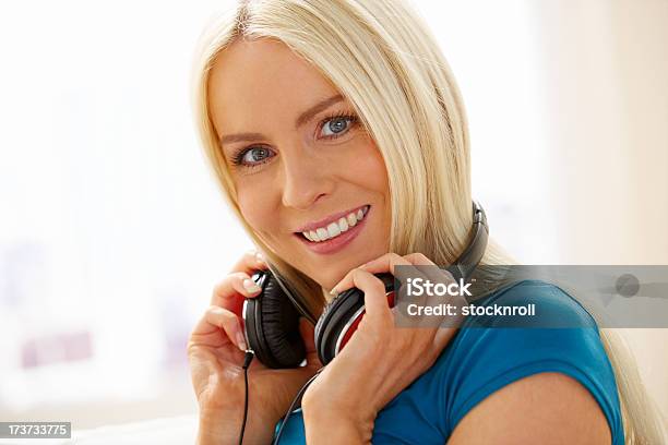 Photo libre de droit de Joyeuse Femme Avec Un Casque Écouter De La Musique À La Maison banque d'images et plus d'images libres de droit de 20-24 ans