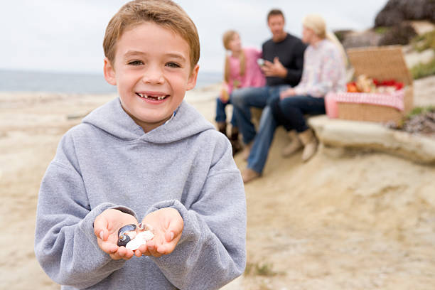 Family at beach with picnic smiling focus on boy