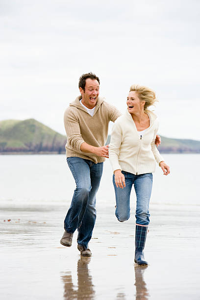 istock Couple running on beach smiling 173734533