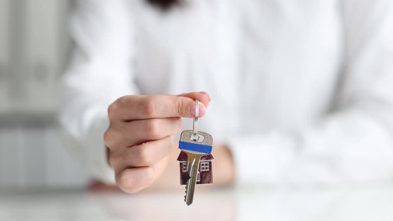 Woman hand shows key to apartment of new house