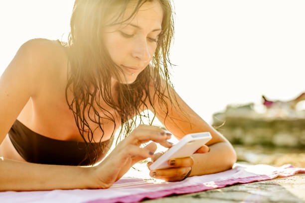 istock Woman using mobile phone on the beach 173734582