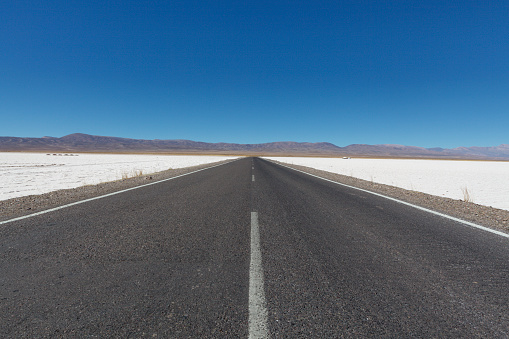 Road through the salt flats of Salinas Grandes, Salta, North Argentina, South America