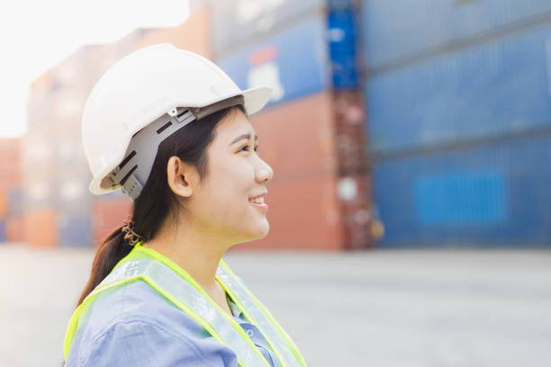 istock Asian woman happy dock worker control loading containers cargo at shipyard. Marine and carrier staff manager employee. cargo loading operator shipping logistics management. 1737350768