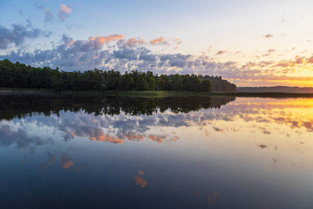 istock Sunrise with clouds and reflection at the lake Schaalsee in Seedorf, Germany 1737367252