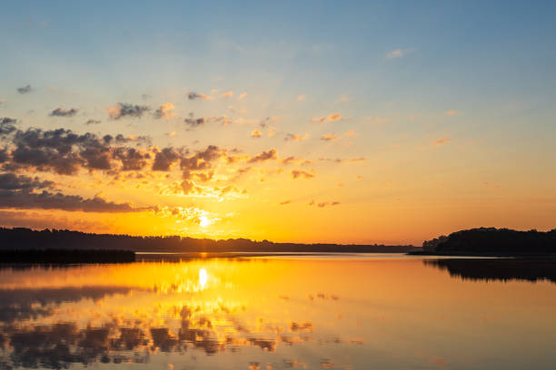 istock Sunrise with clouds and reflection at the lake Schaalsee in Seedorf, Germany 1737367823