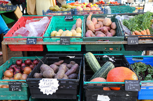 English farmer's market with crates of squash, potatoes, onions and carrots