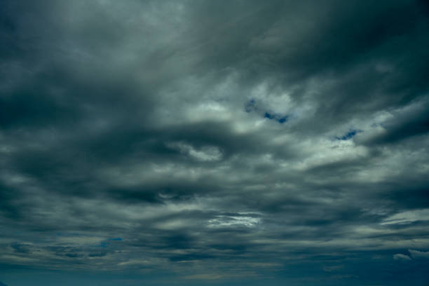 Beautiful sunrise clouds on a summer morning with pinks and blues. Cloudy cloud background and texture. Cluster of clouds with gloomy colors. Sunrise sky landscape travel serene tranquil view with multiple beautiful natural colors.