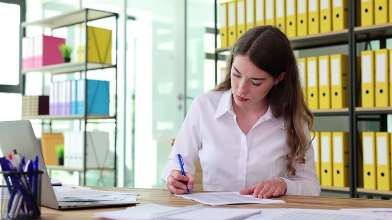 Businesswoman CEO quickly signs necessary reports in office