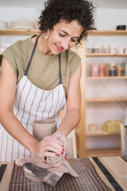 istock Woman smiling while enjoying creating a handmade ceramic piece in a workshop. 1737420146
