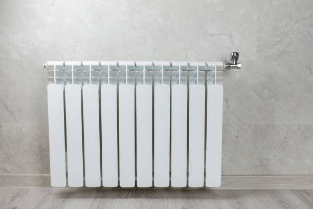 istock Modern radiator at home. Central heating system.Heating radiator, White radiator in the apartment. Expensive heating costs concept, close-up.Heating season.Space for text.MOCKUP 1737428559