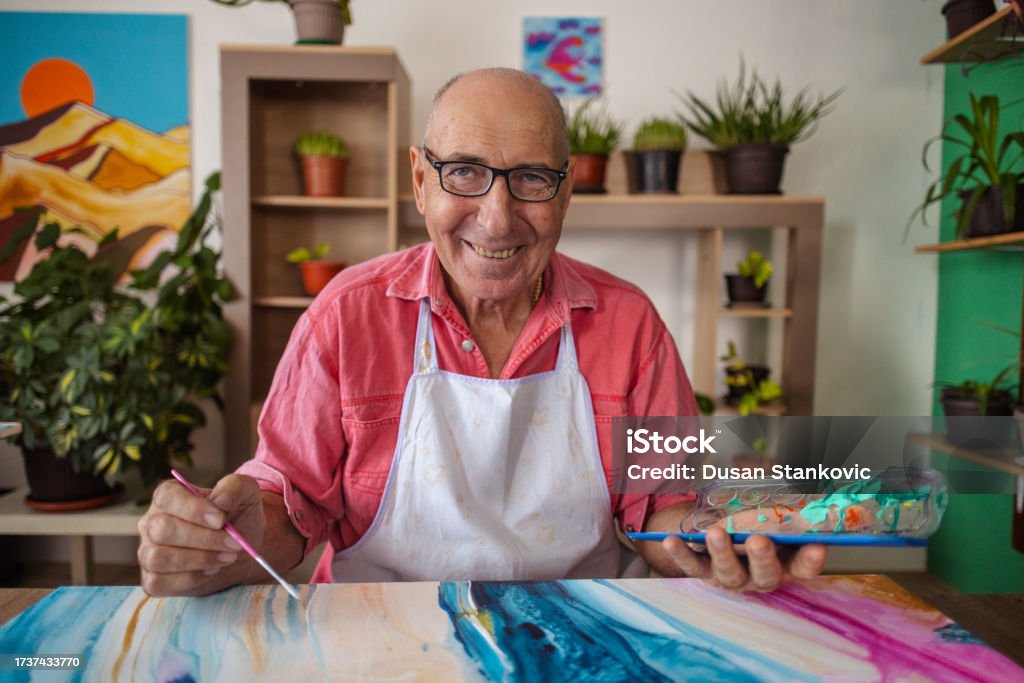 Watercolor Painting by a Senior Artist An elderly painter finds fulfillment in the act of painting, using watercolors to evoke emotions and inspiration. 70-79 Years Stock Photo