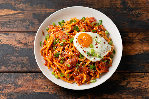Kimchi Fried Udon Noodle with Fried Egg and bacon. Korean food