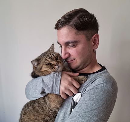 Cat and young man looking at camera with selfie