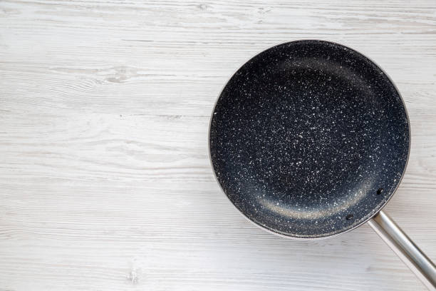 istock Empty Nonstick Frying Pan Skillet on a white wooden background. Space for text. 1737444485