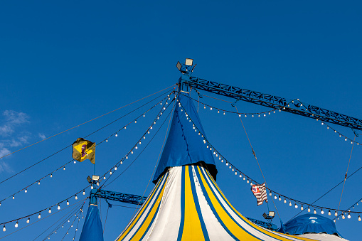 Circus tent blue, yellow and white striped pattern  with Brazil and Sao Paulo state  flag, against the blue sky