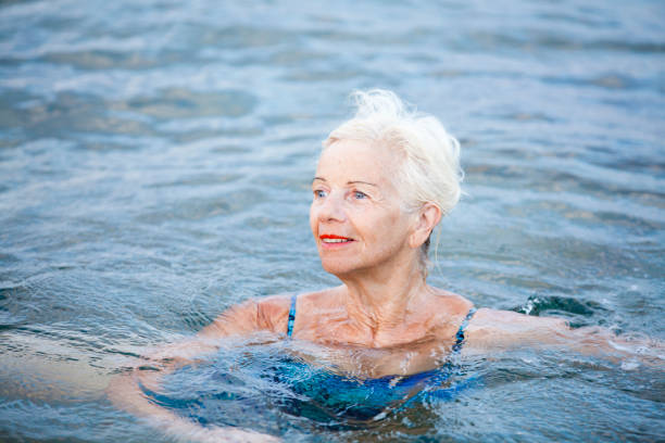 istock Happy elderly woman doing exercises in water 173745274