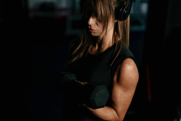 istock Woman in gym lifting heavy weights. 1737459149