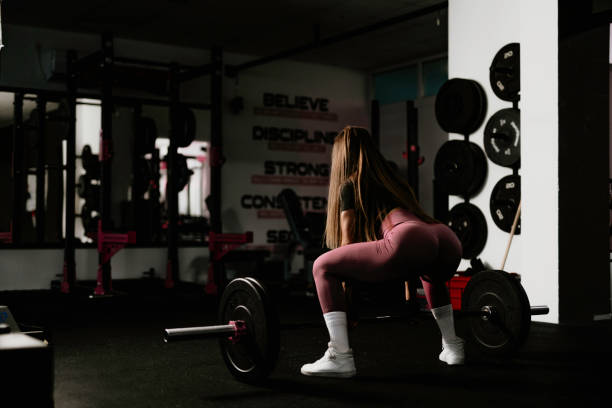 istock Woman in gym lifting heavy weights. 1737463430