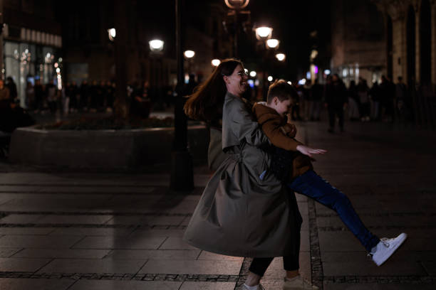 As the moon casts a gentle glow on the city street, a devoted mother and her young son embark on an unforgettable journey