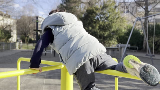 Adventurous Playground Ride, Boy Leaps onto Moving Carousel, Showcasing Radical Moves