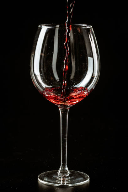 istock Red wine being poured in a wine glass on a dark background 1737472324