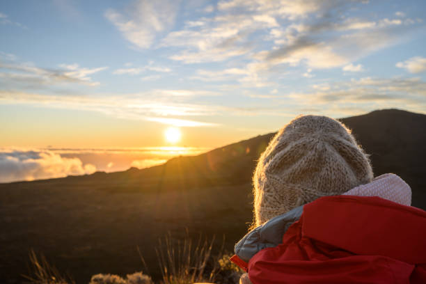 gros plan de l’arrière de la tête d’un touriste portant une casquette et profitant de la lumière atmosphérique et colorée du soleil derrière le volcan tombant sur la mer de lave solidifiée dans la caldeira. piton de la fournaise, ile de la réun - solidified photos et images de collection