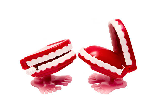 Tooth decay (cavities or caries). Model of a jaw with teeth on a turquoise background. Wooden toy teeth and mouth.