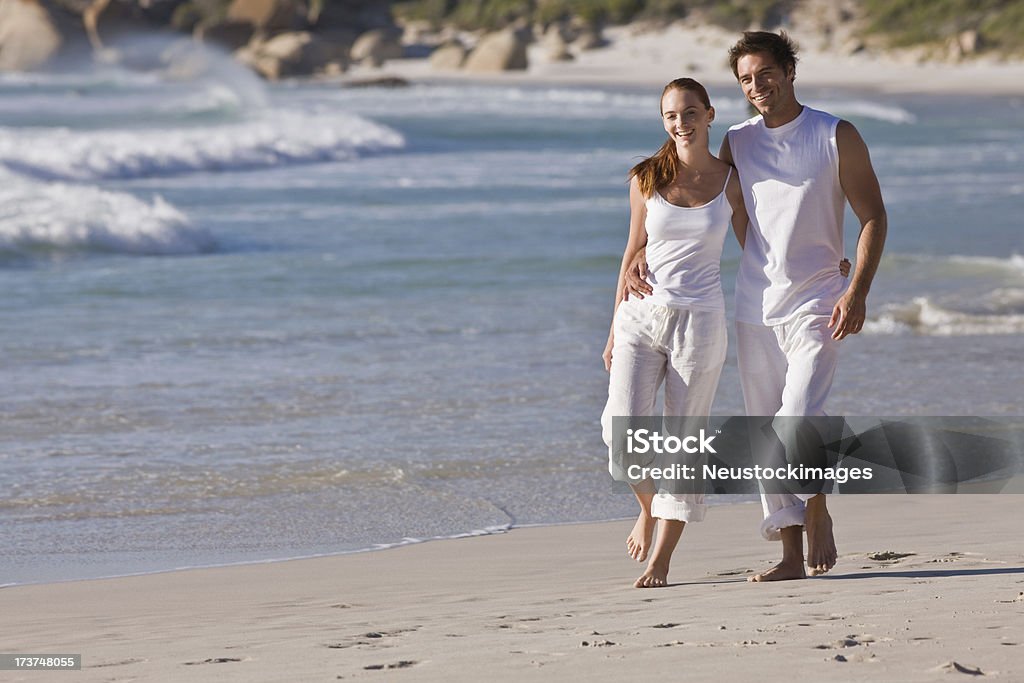 Heureux jeune couple marcher ensemble sur la plage - Photo de 20-24 ans libre de droits