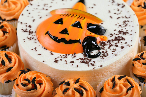 Spooky Halloween chocolate cake with meringue ghosts and candy eyes.  Dark  background