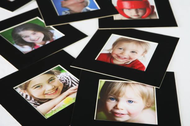 istock Family pictures in black frame scattered on white surface 173748582