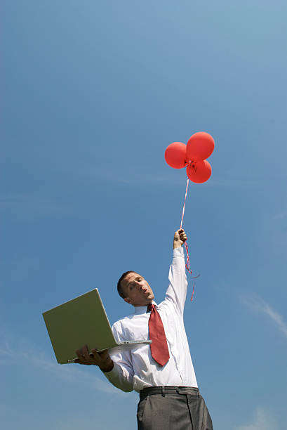 empresário flutua no céu com balões e computador portátil - computer humor stranded business imagens e fotografias de stock
