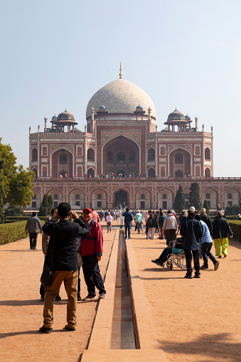 2nd February, 2020 - Delhi, India: This editorial image focuses on the Humayun's Tomb complex, one of Delhi's most iconic landmarks and a UNESCO World Heritage site. Built in 1570, the tomb set a precedent for future Mughal architecture, including the Taj Mahal. Tourists and visitors captured in the photograph are seen exploring the well-maintained gardens, engaging with the architectural intricacies, and taking snapshots to remember their visit. The image offers a glimpse into the balance of historical significance and modern-day tourism that characterises this important cultural site.