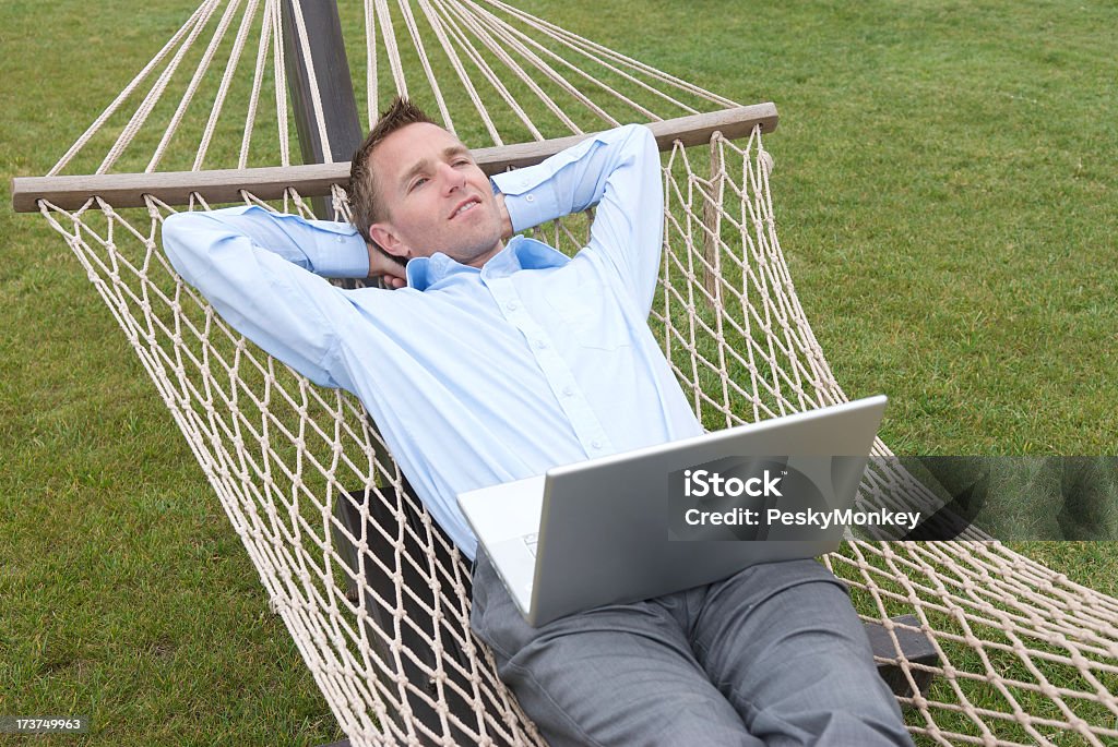Biznesmen leżącej na zewnątrz Daydreaming w hamaku z laptopa - Zbiór zdjęć royalty-free (Biznes)