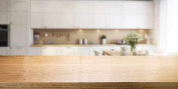 istock empty brown wooden tabletop for product display on blurred white modern home kitchen interior background. banner with copy space 1737501173