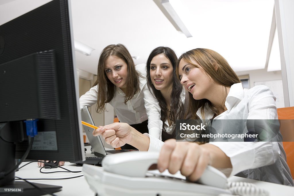 Businesswomen working Businesswoman working on pc, two businesswomen in the background, canon 1Ds mark III Adult Stock Photo