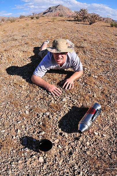 homme ramper pour l'eau dans le désert - thirsty desert men reaching photos et images de collection