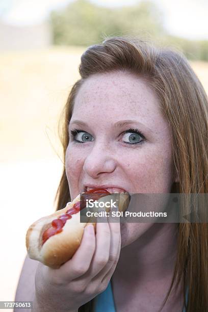 Ragazza Mordere Una Deliziosa Hot Dog - Fotografie stock e altre immagini di Hot Dog - Hot Dog, Mangiare, Solo una donna