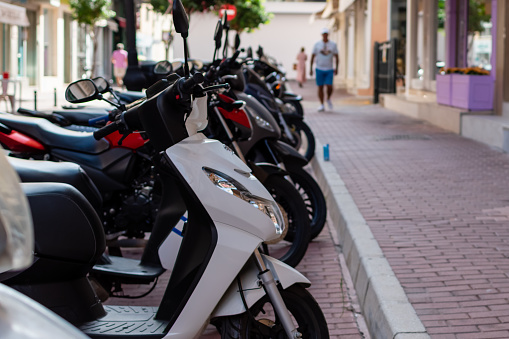 Motorbikes in parking area on blurred background of city street. Spain, Fuengirola, September 18, 2023