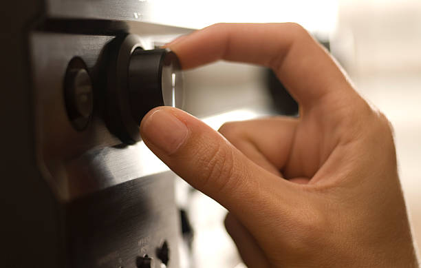 Hand adjusting electronics. Turn it up! volume knob stock pictures, royalty-free photos & images