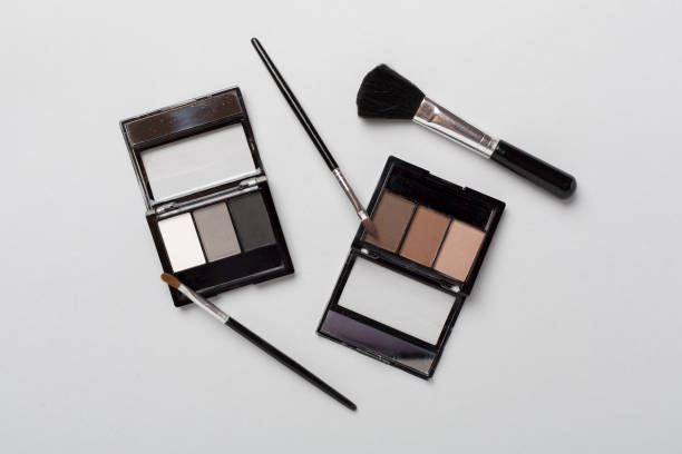 istock Eye shadows with brushes on color background, top view 1737533839