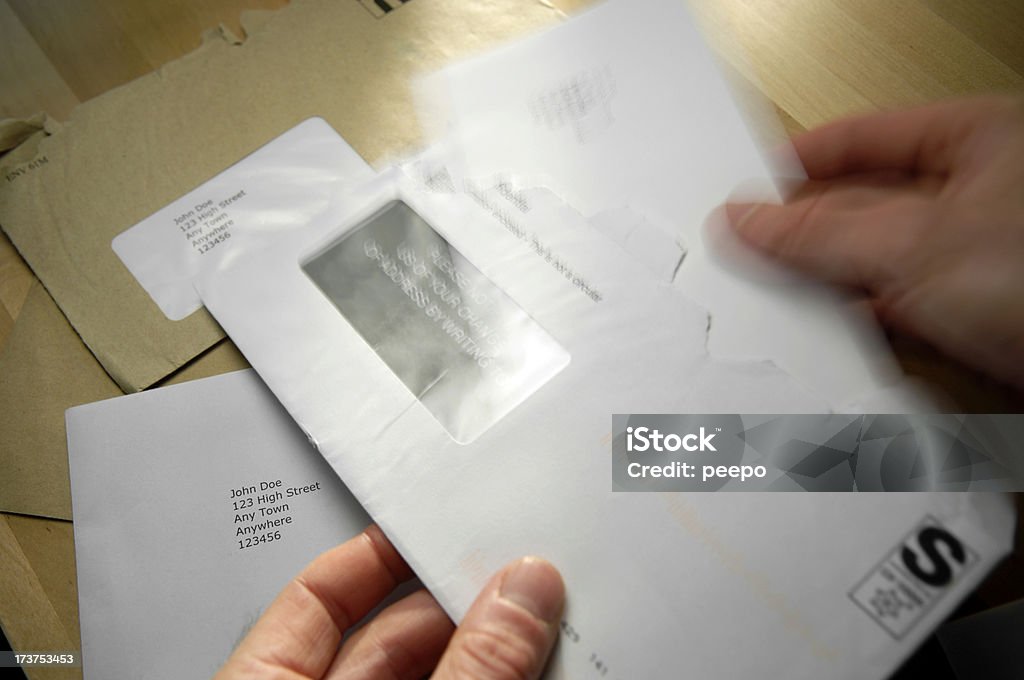 opening mail selective focus image of hand opening letter Desk Stock Photo