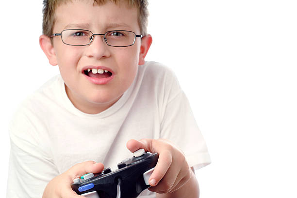 Image of boy intensely playing a video game. Game controller and hands are in sharp focus the boy is not in focus.