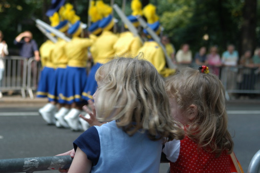 Two little girls intently watching a parade.