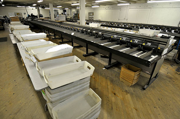 Mass Mail Operation "Sorting bins in a mass mail shop that is mostly automated, mailing hundreds of thousands of bill and such daily. Workers are at the far end of the room." filing tray stock pictures, royalty-free photos & images