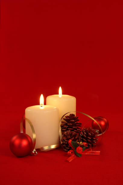 istock Christmas Candles, pine cones and baubles isolated on red 173754628