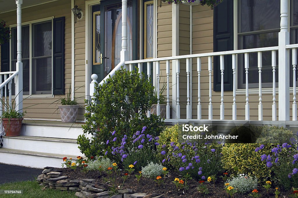 Homes - Inviting Entrance II "A view of the warm and inviting entrance to a home.  Beautiful landscaping and decorative plants are visible on and in front of the steps and porch. Contemporary center hall colonial style. Long Island, New York, USA." Flower Stock Photo