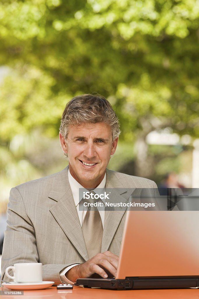 Sorridente maturo Uomo d'affari che lavorano su computer portatile - Foto stock royalty-free di 50-54 anni