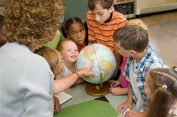 istock Female teacher conducting geography lesson with her class 173755405