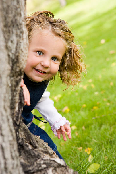 istock Happy Little Girl Hiding Behind Tree 173755670