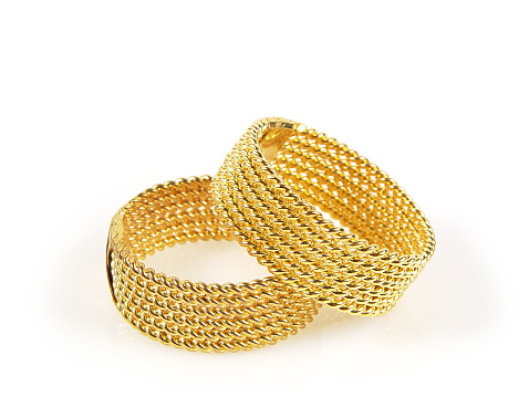 Pair of braided gold rings, brightly lit on white background, perfect for wedding, romance, trust, wealth. Matching style and size ideal for gay marriage concept.